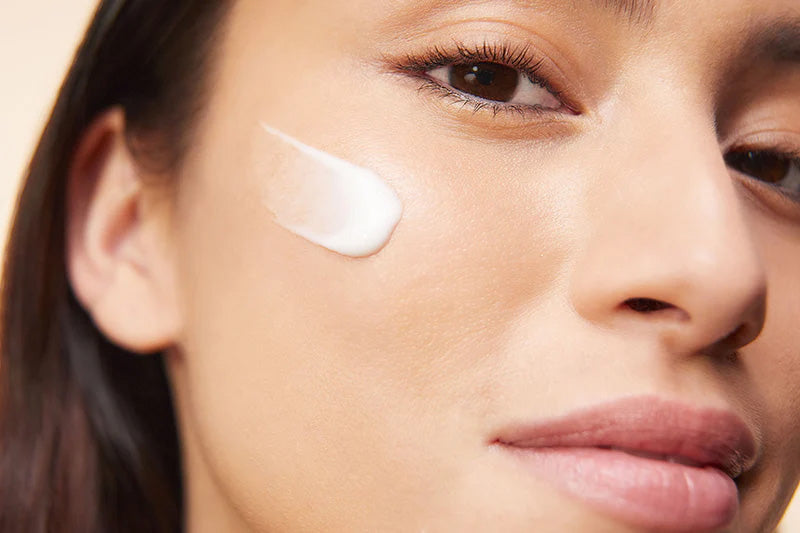 Woman with moisturizer smear on her cheek